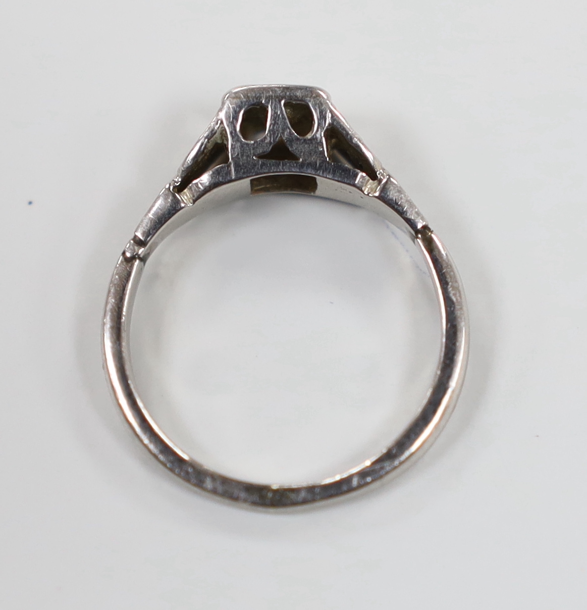 A white metal (stamped PALL?) and illusion set single stone diamond ring, size J/K, gross weight 2.3 grams.